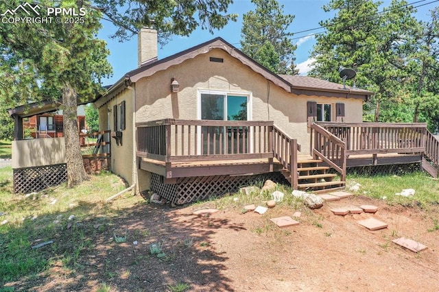 205 N Laurel St, Woodland Park, CO 80863 - rear view of property featuring a chimney, stucco siding, and a deck