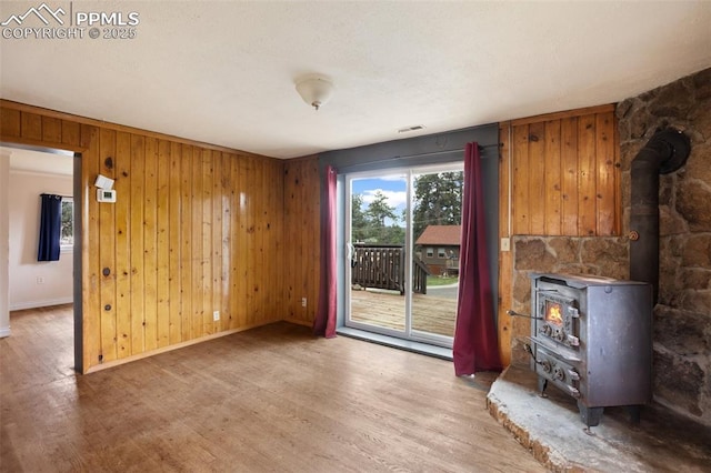 205 N Laurel St, Woodland Park, CO 80863 - unfurnished living room with a wood stove, wood finished floors, and wooden walls