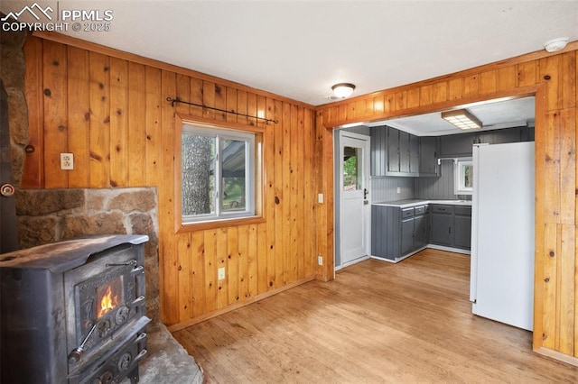 205 N Laurel St, Woodland Park, CO 80863 - unfurnished living room with light wood finished floors, a wood stove, and wooden walls