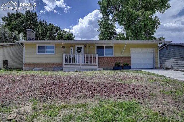 1222 Hartford St, Colorado Springs, CO 80906 - ranch-style house featuring brick siding, a garage, a porch, driveway, and a chimney