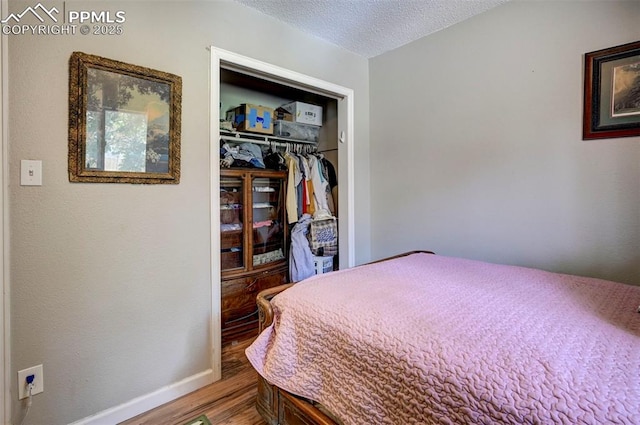 1222 Hartford St, Colorado Springs, CO 80906 - bedroom featuring wood finished floors, a closet, and a textured ceiling
