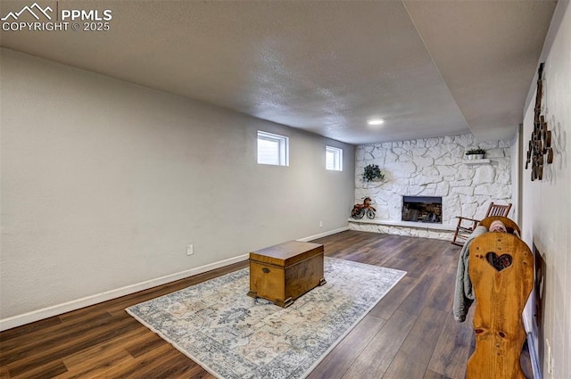 1222 Hartford St, Colorado Springs, CO 80906 - living room with a stone fireplace, dark wood-style flooring, and a textured ceiling