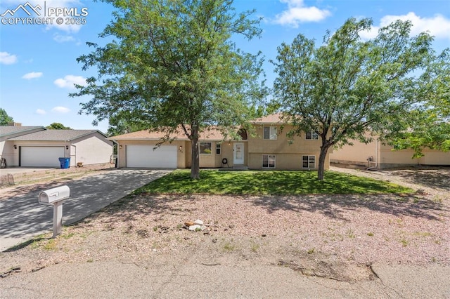 204 E Arvada Dr, Pueblo West, CO 81007 - split level home featuring driveway, a garage, and a front yard