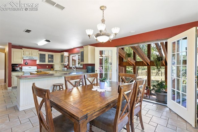 4115 Hay Creek Rd, Colorado Springs, CO 80921 - dining area with plenty of natural light, a chandelier, and light stone finish floors
