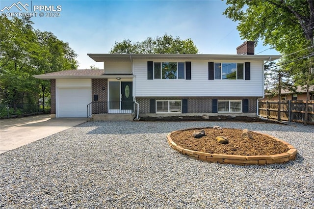 33 N Belmont St, Colorado Springs, CO 80911 - view of front facade with a chimney, a garage, brick siding, and driveway