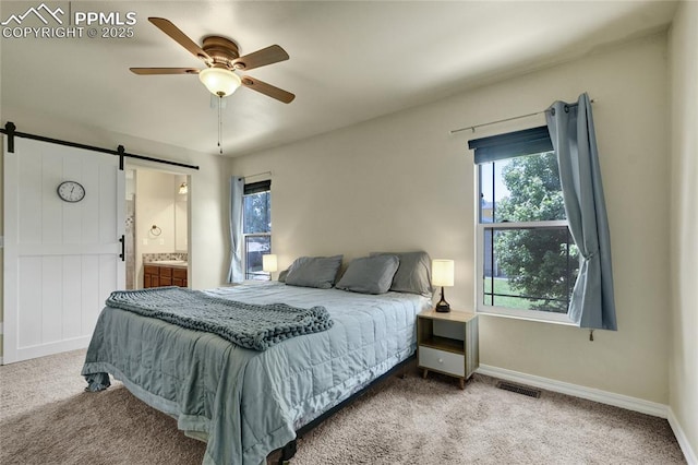2601 Lynbarton Pt, Colorado Springs, CO 80918 - carpeted bedroom with a barn door, multiple windows, a ceiling fan, and ensuite bathroom