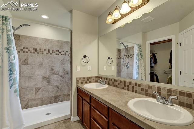 2601 Lynbarton Pt, Colorado Springs, CO 80918 - full bathroom with a shower stall, a walk in closet, double vanity, and backsplash