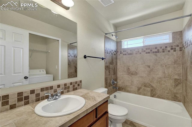 2601 Lynbarton Pt, Colorado Springs, CO 80918 - bathroom with washer / clothes dryer, vanity, bathtub / shower combination, and backsplash
