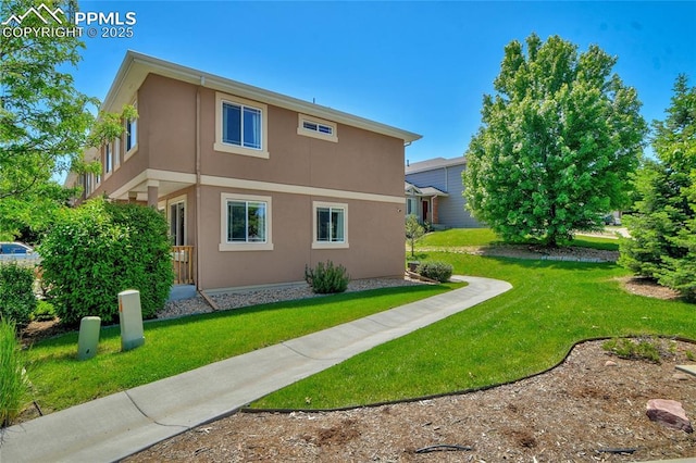 2601 Lynbarton Pt, Colorado Springs, CO 80918 - rear view of house featuring stucco siding and a yard