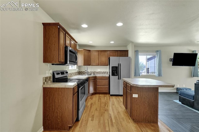 2601 Lynbarton Pt, Colorado Springs, CO 80918 - kitchen featuring stainless steel appliances, light countertops, a center island, light wood-style flooring, and recessed lighting