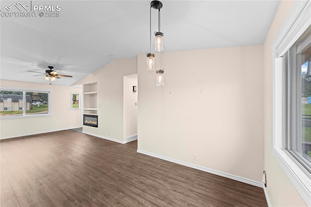 1005 Mountain View Rd, Woodland Park, CO 80863 - unfurnished living room with lofted ceiling, dark wood-type flooring, a ceiling fan, a glass covered fireplace, and built in features