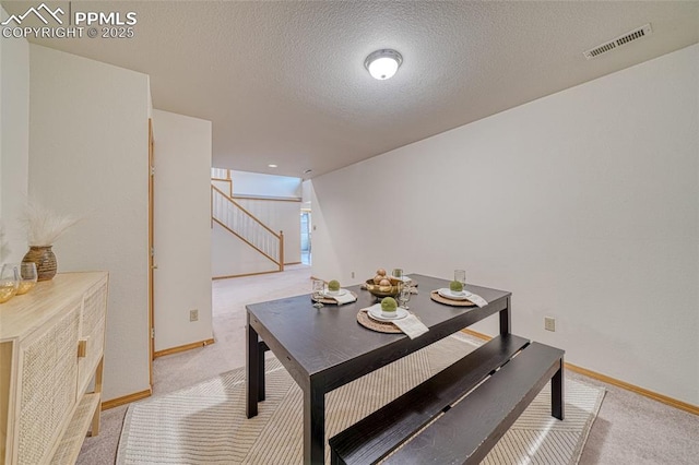 1520 Ledge Rock Ter, Colorado Springs, CO 80919 - dining space featuring light colored carpet, stairs, and a textured ceiling
