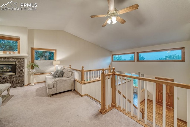 1520 Ledge Rock Ter, Colorado Springs, CO 80919 - sitting room with an upstairs landing, lofted ceiling, a ceiling fan, a premium fireplace, and carpet flooring