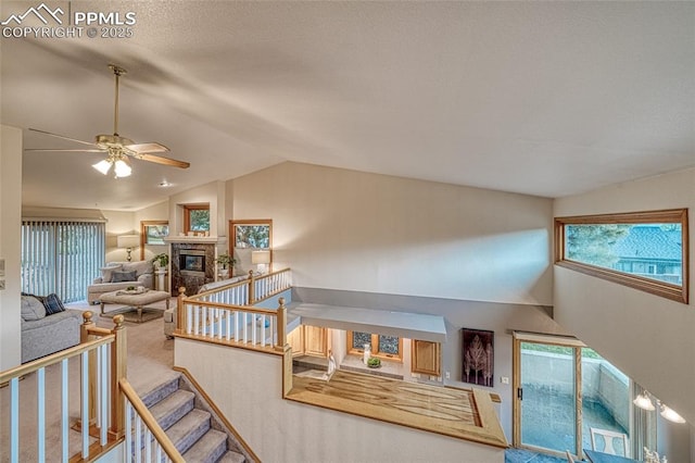 1520 Ledge Rock Ter, Colorado Springs, CO 80919 - staircase with lofted ceiling, carpet, ceiling fan, and a glass covered fireplace