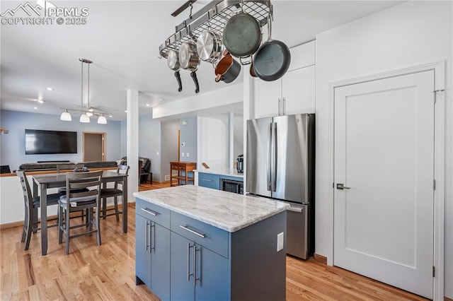 2664 Emerald Ridge Dr, Colorado Springs, CO 80920 - kitchen featuring freestanding refrigerator, light wood-type flooring, a kitchen island, blue cabinetry, and recessed lighting