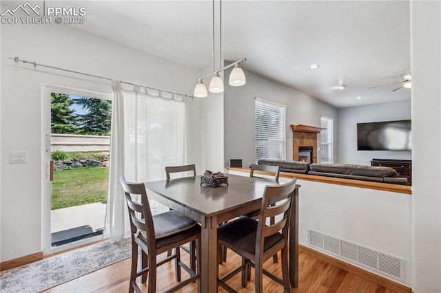 2664 Emerald Ridge Dr, Colorado Springs, CO 80920 - dining area featuring healthy amount of natural light, light wood-style floors, a tile fireplace, ceiling fan, and recessed lighting