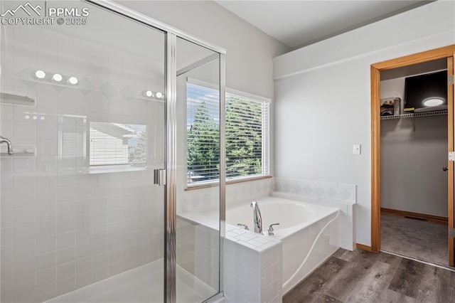 2664 Emerald Ridge Dr, Colorado Springs, CO 80920 - full bathroom featuring wood finished floors, a shower stall, a bath, and a spacious closet