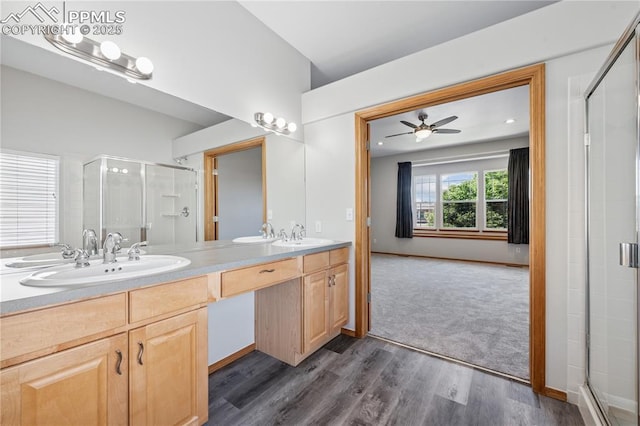 2664 Emerald Ridge Dr, Colorado Springs, CO 80920 - full bathroom featuring a stall shower, double vanity, wood finished floors, and ceiling fan