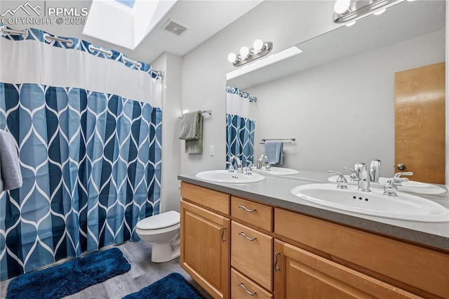 2664 Emerald Ridge Dr, Colorado Springs, CO 80920 - bathroom with double vanity, wood finished floors, and a shower with curtain