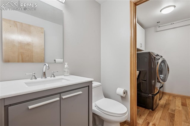 2664 Emerald Ridge Dr, Colorado Springs, CO 80920 - half bath with washer and dryer, wood finished floors, and vanity