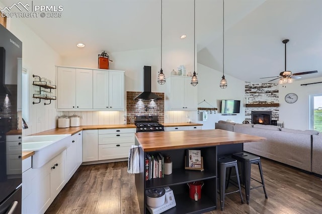 6975 H T Ranch Trl, Colorado Springs, CO 80908 - kitchen with butcher block countertops, extractor fan, open shelves, range with gas stovetop, and ceiling fan