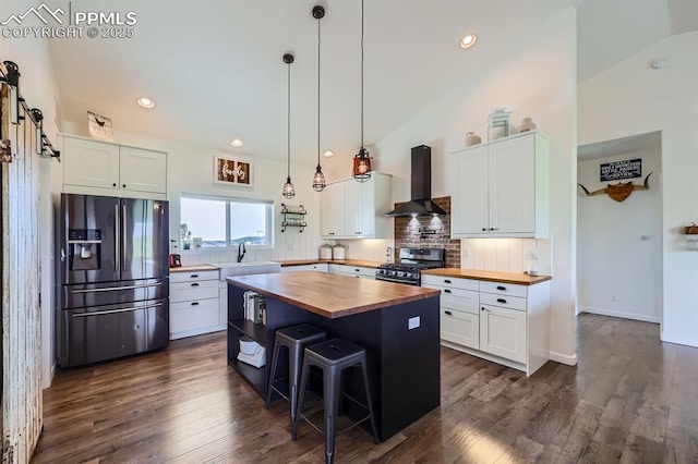 6975 H T Ranch Trl, Colorado Springs, CO 80908 - kitchen featuring butcher block countertops, refrigerator with ice dispenser, wall chimney exhaust hood, stainless steel gas stove, and backsplash