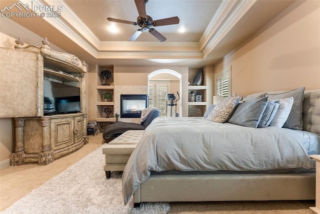 2585 Dunfries Ct, Colorado Springs, CO 80919 - carpeted bedroom with ornamental molding, a tray ceiling, arched walkways, and a ceiling fan