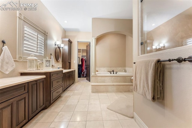 2585 Dunfries Ct, Colorado Springs, CO 80919 - full bathroom with decorative columns, vanity, a bath, tile patterned floors, and a spacious closet