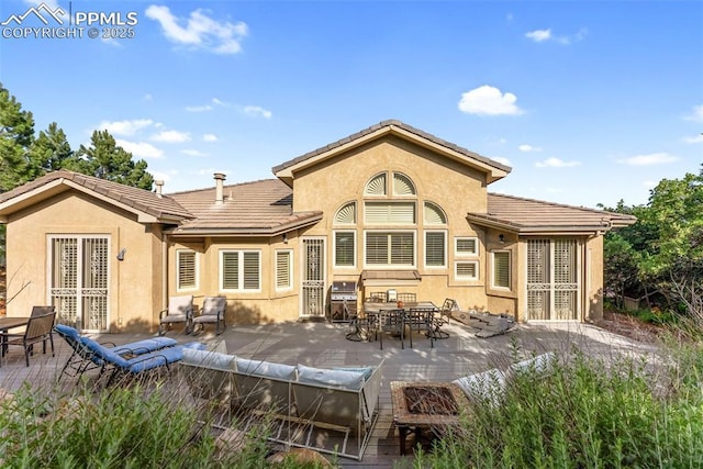 2585 Dunfries Ct, Colorado Springs, CO 80919 - rear view of property featuring stucco siding, an outdoor living space, a tile roof, and a patio area