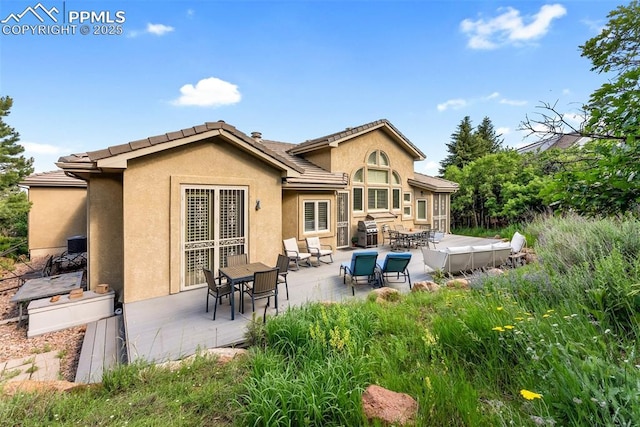 2585 Dunfries Ct, Colorado Springs, CO 80919 - rear view of property with stucco siding, outdoor dining space, a patio area, and a tiled roof