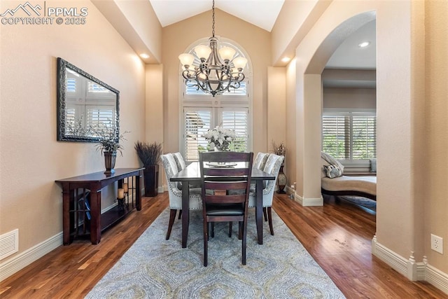 2585 Dunfries Ct, Colorado Springs, CO 80919 - dining area featuring a chandelier, arched walkways, wood finished floors, and high vaulted ceiling