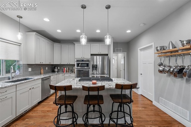 501 N Franklin St, Colorado Springs, CO 80903 - kitchen with stainless steel appliances, decorative backsplash, a kitchen island, recessed lighting, and light wood-type flooring
