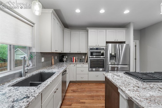 501 N Franklin St, Colorado Springs, CO 80903 - kitchen featuring stainless steel appliances, white cabinetry, recessed lighting, light wood-type flooring, and backsplash