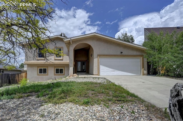 5926 Del Paz Dr, Colorado Springs, CO 80918 - view of front facade featuring stucco siding, an attached garage, and driveway