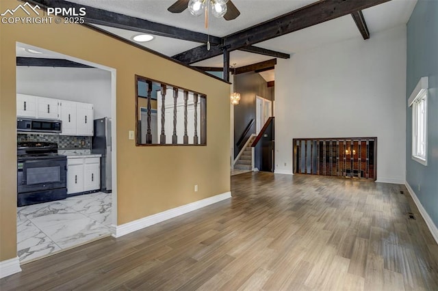 5926 Del Paz Dr, Colorado Springs, CO 80918 - unfurnished living room with ceiling fan, beam ceiling, stairs, and light wood-style flooring