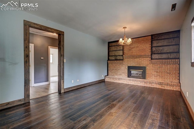 5926 Del Paz Dr, Colorado Springs, CO 80918 - unfurnished living room with wood finished floors, a chandelier, and a brick fireplace