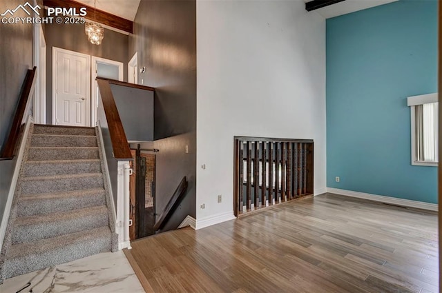 5926 Del Paz Dr, Colorado Springs, CO 80918 - staircase with a high ceiling, wood finished floors, a chandelier, and beamed ceiling