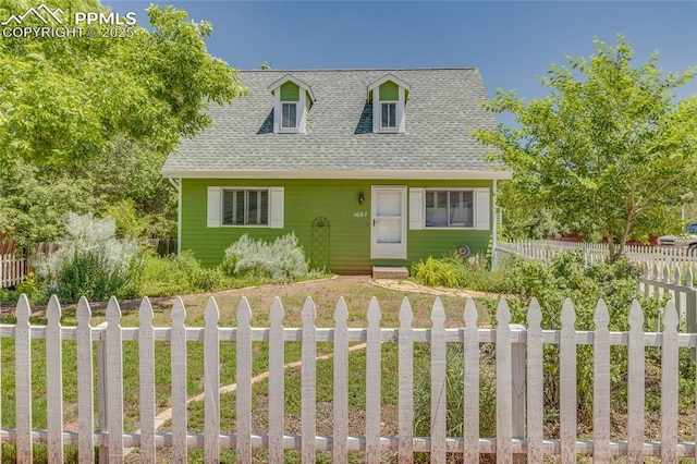 1607 N Chestnut St, Colorado Springs, CO 80907 - cape cod-style house with a shingled roof, a fenced front yard, and driveway