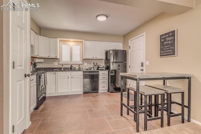 1607 N Chestnut St, Colorado Springs, CO 80907 - kitchen with black appliances, dark countertops, and white cabinetry