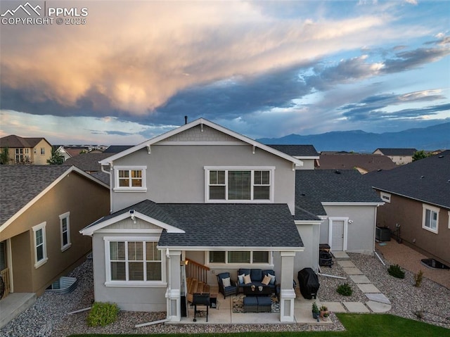 4296 New Santa Fe Trl, Colorado Springs, CO 80924 - back of house with an outdoor living space, a patio, a mountain view, roof with shingles, and stucco siding