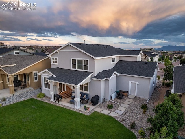 4296 New Santa Fe Trl, Colorado Springs, CO 80924 - back of house at dusk featuring entry steps, roof with shingles, stucco siding, and a patio area