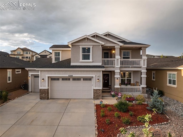 4296 New Santa Fe Trl, Colorado Springs, CO 80924 - craftsman inspired home featuring covered porch, driveway, stone siding, a balcony, and an attached garage