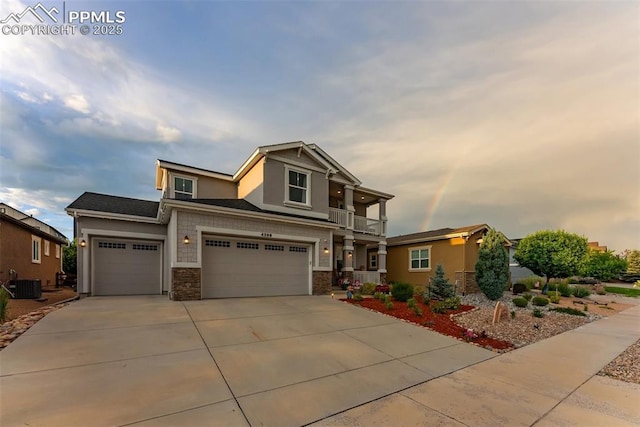 4296 New Santa Fe Trl, Colorado Springs, CO 80924 - view of front facade with a balcony, stone siding, concrete driveway, and an attached garage