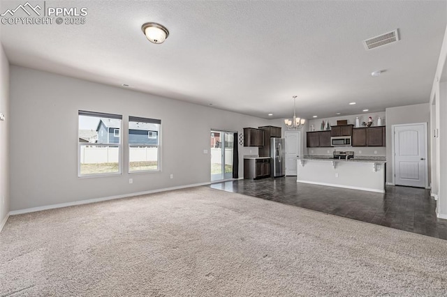 10726 Traders Pkwy, Fountain, CO 80817 - unfurnished living room featuring a chandelier, dark carpet, and recessed lighting
