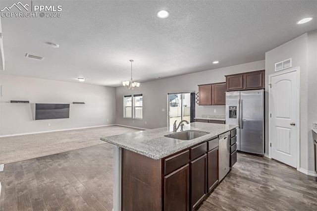 10726 Traders Pkwy, Fountain, CO 80817 - kitchen featuring appliances with stainless steel finishes, open floor plan, dark wood finished floors, a textured ceiling, and a chandelier
