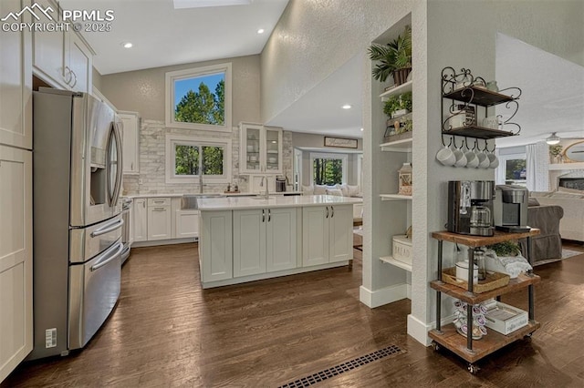 970 Bend In The Trail Rd, Monument, CO 80132 - kitchen featuring stainless steel fridge, open floor plan, light countertops, a towering ceiling, and dark wood finished floors