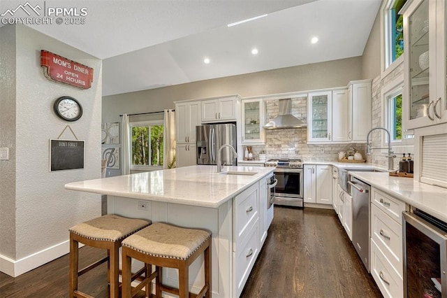 970 Bend In The Trail Rd, Monument, CO 80132 - kitchen featuring stainless steel appliances, wall chimney exhaust hood, wine cooler, dark wood finished floors, and tasteful backsplash