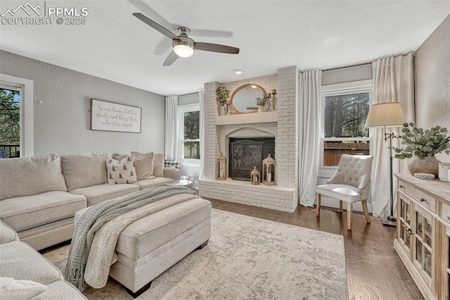 970 Bend In The Trail Rd, Monument, CO 80132 - living area with a textured wall, a brick fireplace, wood finished floors, and ceiling fan