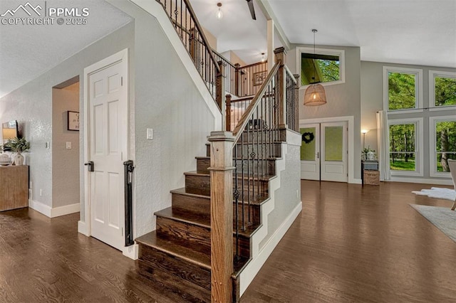 970 Bend In The Trail Rd, Monument, CO 80132 - stairs featuring wood finished floors, a textured wall, and a high ceiling