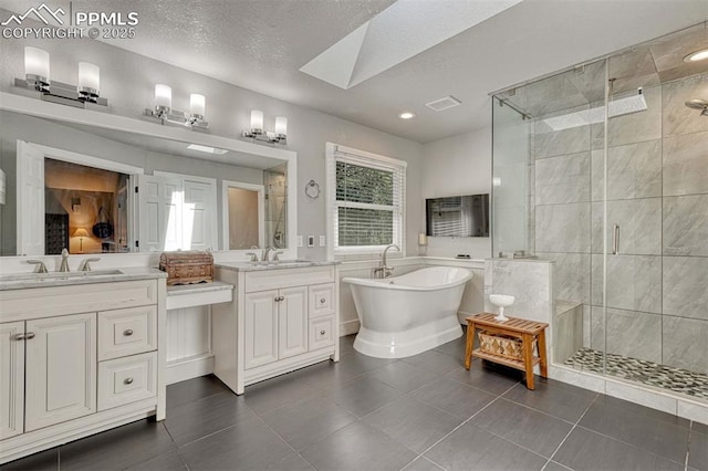 970 Bend In The Trail Rd, Monument, CO 80132 - full bathroom with a shower stall, two vanities, plenty of natural light, a freestanding tub, and recessed lighting